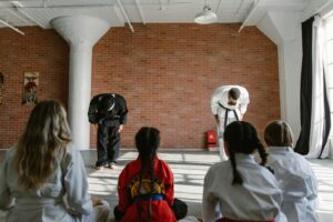 Martial arts teachers bowing to students in a dojo, demonstrating respect and discipline.